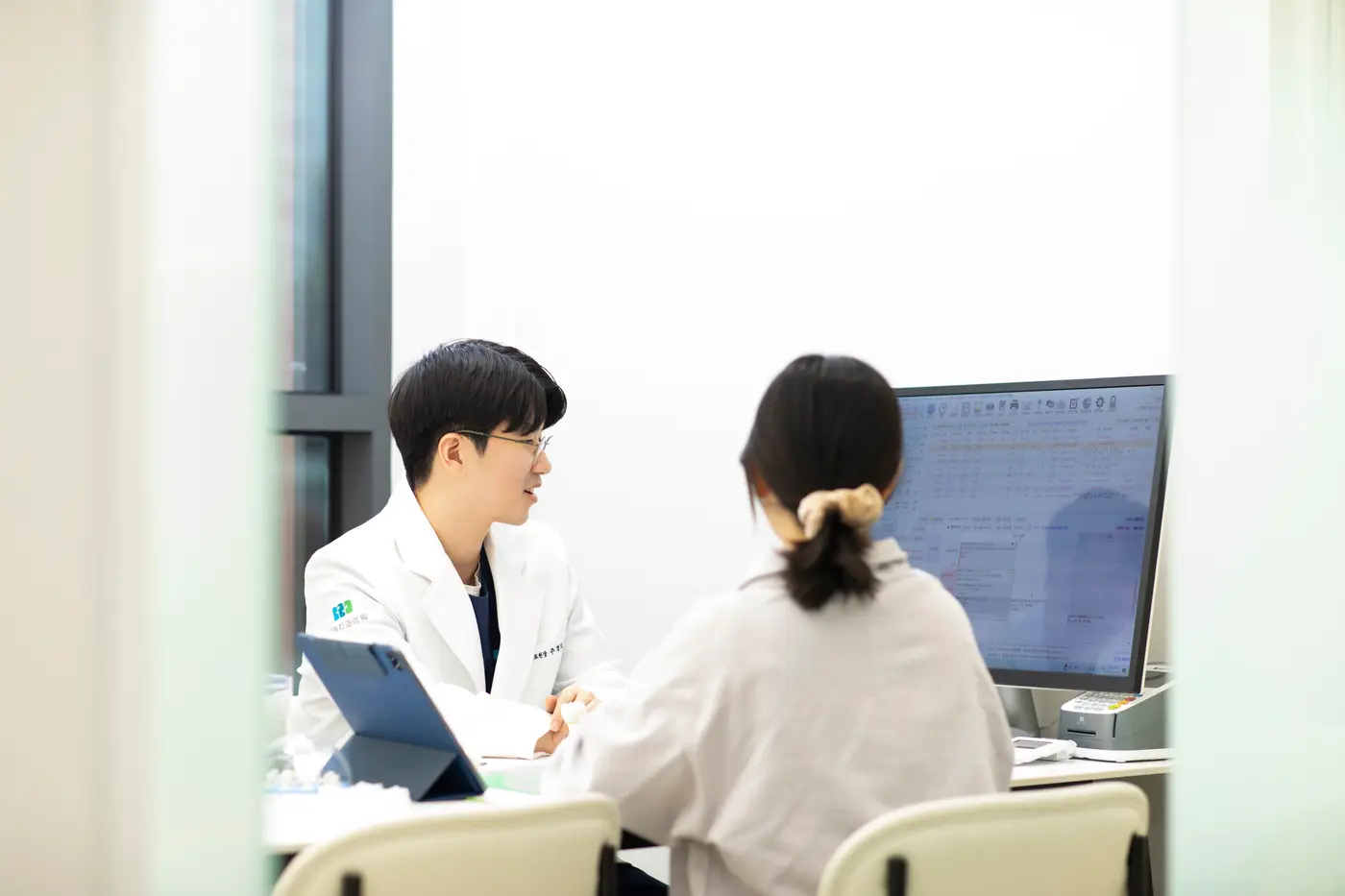 원장이 모니터의 구강 사진을 보며 환자에게 설명하는 모습