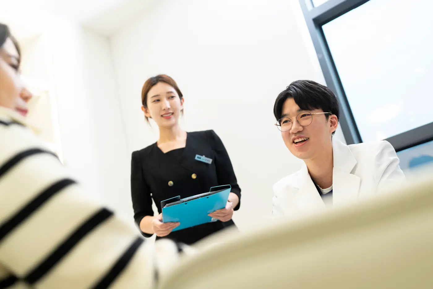 원장과 상담실장이 환자와 웃으며 상담하는 모습
