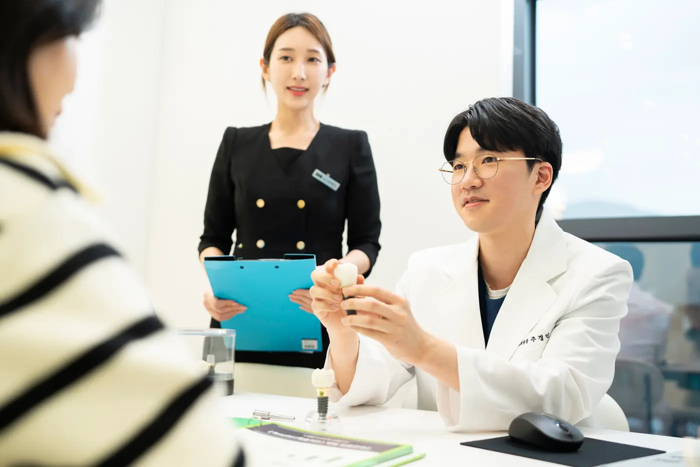 원장과 상담실장이 환자에게 치료 계획을 설명하는 모습